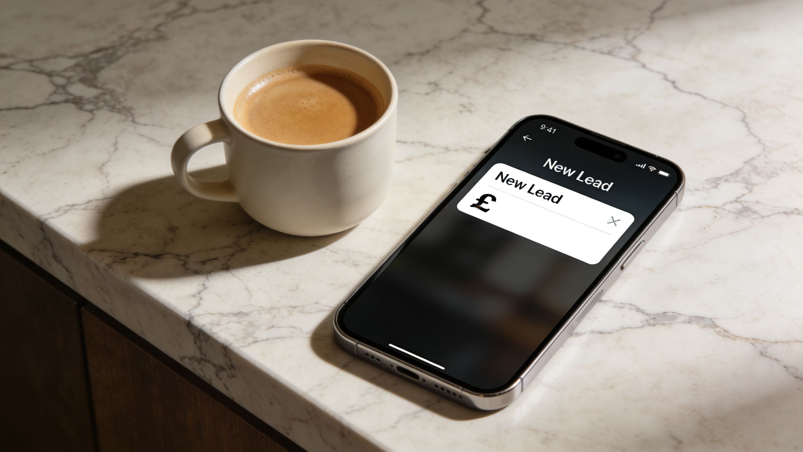 A smartphone on a marble countertop displaying a new lead input form with a British pound symbol.